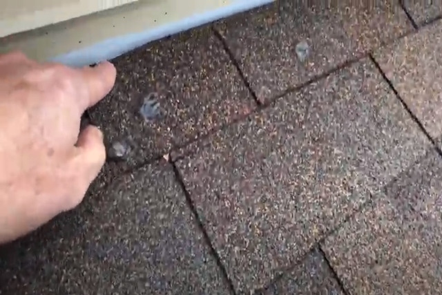 Worker checking roof for leak by doing roof inspection